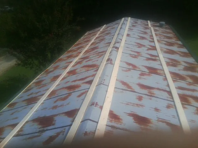 Rusted metal roof panels with new wood purlins before replacement — Storm Damage Roof Repair in Gypsum by Roofing Brothers