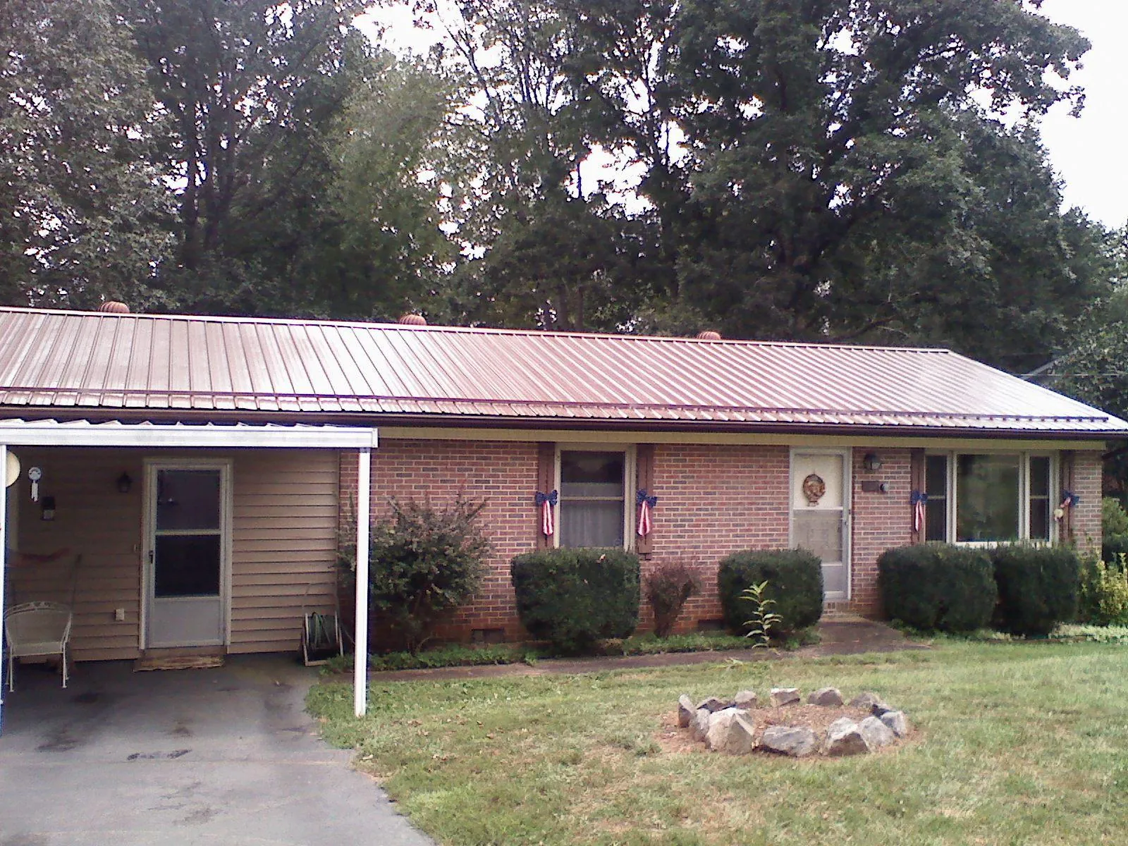 Bronze metal roof and carport on a brick ranch home — Roof Repair work by our crew in Gypsum